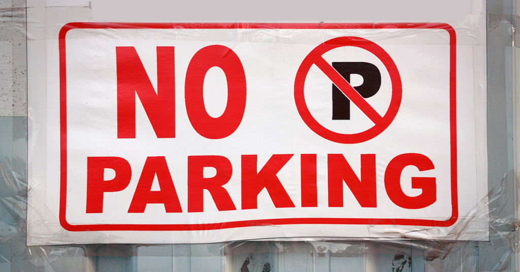 Bold red No Parking sign displayed on a wall, referencing tightened UK motorhome parking rules and shifting public debate in 2025.